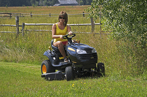 The young woman on riding lawn mower