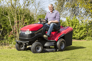 senior gardener mowing the lawn with tractor France